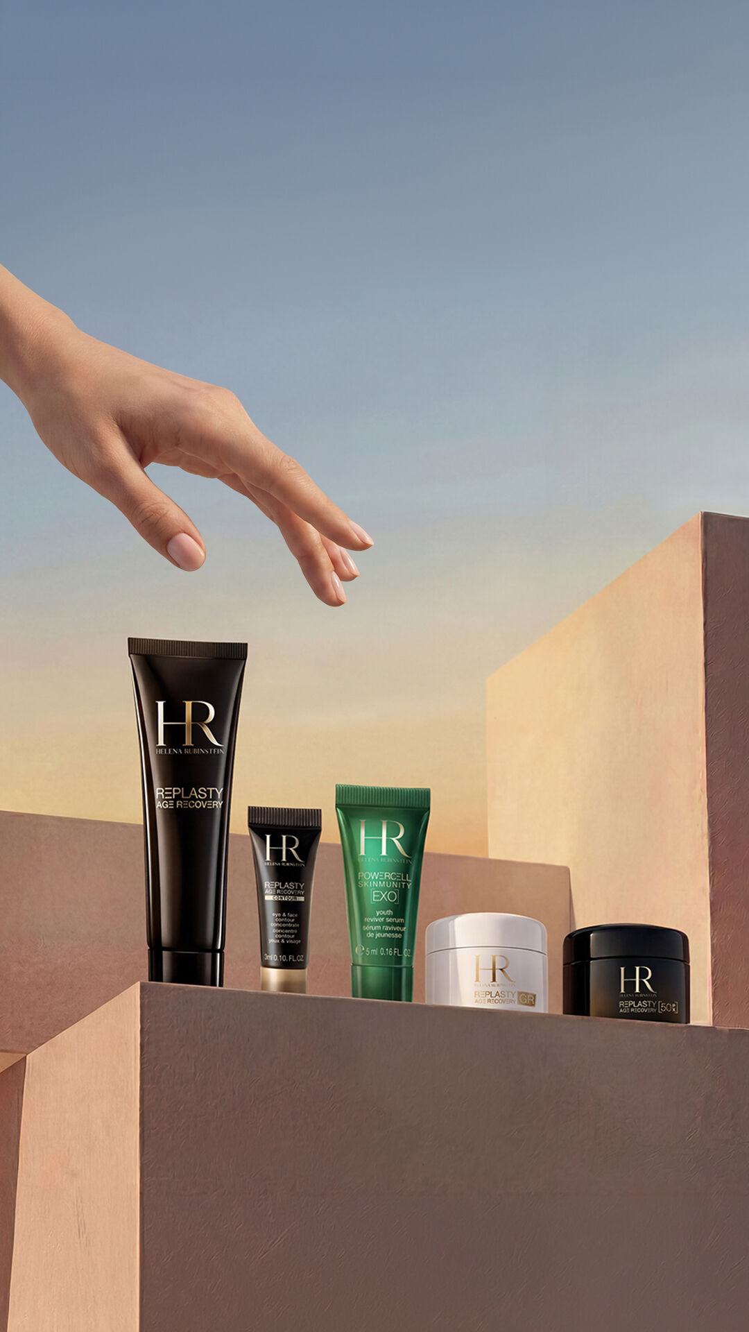 Une main elegante survole une selection de produits de soin de la gamme Replastasty et Powercell disposes sur des podiums geometriques aux tons nude et poudres, sur fond de ciel clair au crepuscule.