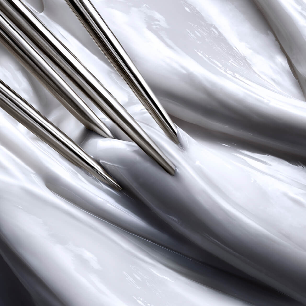 Nahaufnahme einer dicken, strukturierten weißen Creme mit mehreren scharfen Metallnadeln, die an einen asthetischen oder medizinischen Eingriff erinnern.