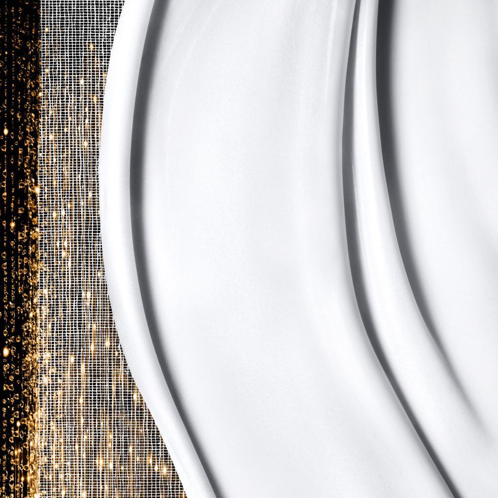 Glatte, cremeweiße Textur mit sanften Wellen auf der rechten Seite, kombiniert mit schimmernden, abstrakten goldenen Mustern auf der linken Seite.